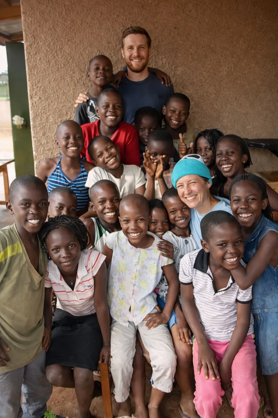 A large, joyful group of children and adults gathered together and smiling