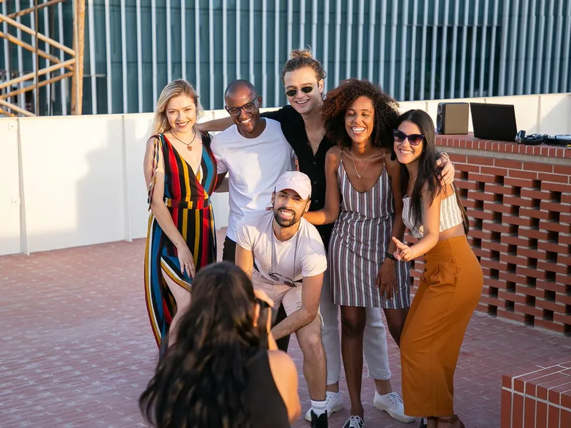 Friends from many backgrounds laughing together on a sunny terrace