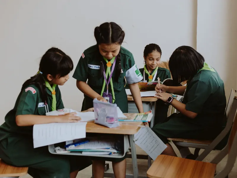 Students working and talking together around a classroom table